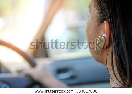Women using hands-free phone while driving a car.