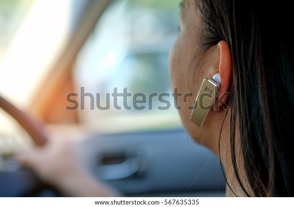 Women using\
hands-free phone while driving a\
car.