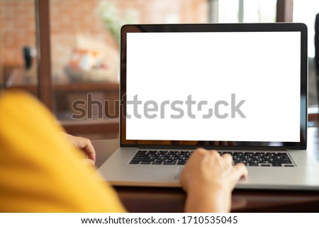 women using laptop computer working at home with blank white desktop screen.