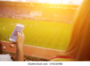 Women Are Using Smart Phone On The Soccer Stadium.