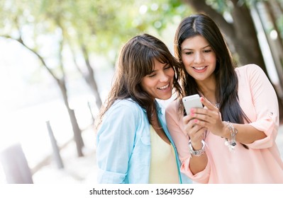 Women Using A Smart Phone Outdoors Looking Very Happy