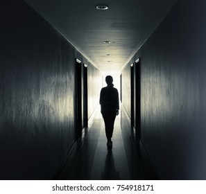 Women are walking alone in the dark.Light at the end of the tunnel concept - Powered by Shutterstock