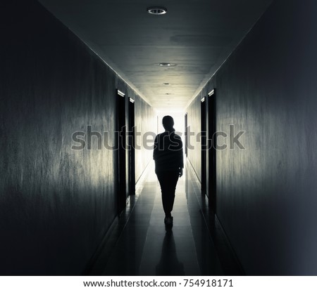 Women are walking alone in the dark.Light at the end of the tunnel concept