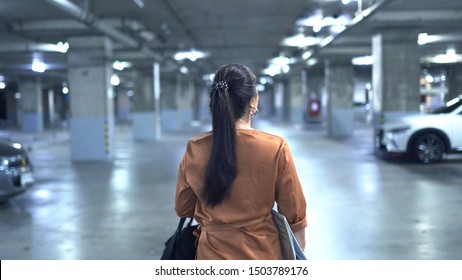 Women Walking Alone In Underground Car Park At Night