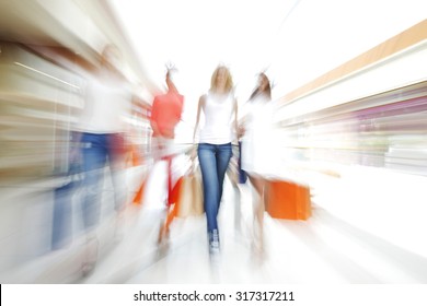 Women Walking Fast In Shopping Mall With Bags