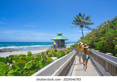 Women walking on boardwalk to beautiful Florida beach. Girls on summer vacation in Florida. Red Reef Park, Boca Raton, Florida USA.