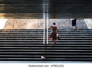 Women walking upstairs wearing dress on symmetric staircase