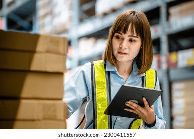 Women warehouse worker using digital tablets to check the stock inventory on shelves in large warehouses, a Smart warehouse management system, supply chain and logistic network technology concept - Powered by Shutterstock