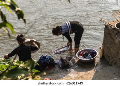 Women washing clothes in a river - Powered by Shutterstock