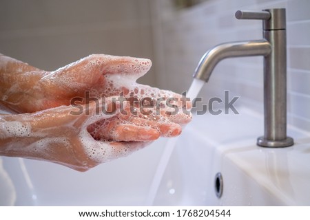 Women are washing their hands with foam soap and clean water. Wash your hands to keep them clean and prevent the spread of viral