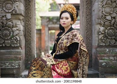 Women wear traditional Balinese kebaya between the relief gates