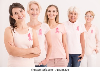 Women wearing pink shirts and breast cancer ribbons on white background - Powered by Shutterstock