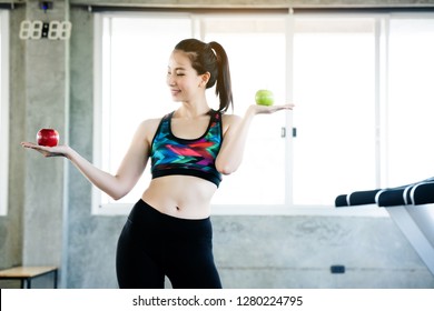 Women Wearing Sportswear Hand Holding Green And Red Apple. Which Is Beneficial To The Body. Good Care Of Her Body By Diet. Eat To Help Digestion. Antioxidants Make The Skin Beautiful. Change Yourself.