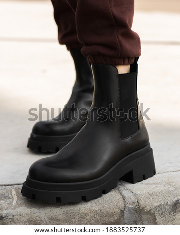Women wearing trendy ankle boots. Outdoor leather boot product photography. 