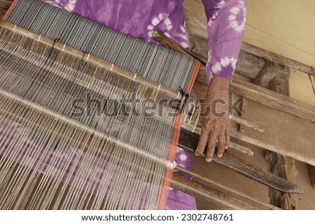 Women weave with traditional tools at home