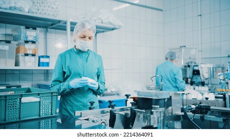 Women Work On The Capsule Packaging Line And Put The Finished Product Into A Box. Bottle Filling Machine. Bottles On A Conveyor Belt. Production Line Of Pharmaceutical Manufacturing