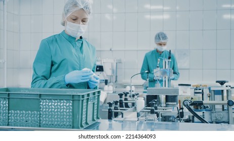 Women Work On The Capsule Packaging Line And Put The Finished Product Into A Box. Bottle Filling Machine. Bottles On A Conveyor Belt. Production Line Of Pharmaceutical Manufacturing