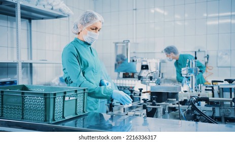 Women Work On The Capsule Packaging Line And Put The Finished Product Into A Box. Bottle Filling Machine. Bottles On A Conveyor Belt. Production Line Of Pharmaceutical Manufacturing