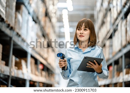Women worker use scanner to check and scan barcodes of stock inventory on shelves to keep storage in a system, Smart warehouse management system, Supply chain and logistic network technology concept.