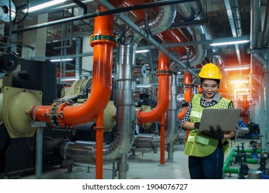 Women Worker Using  Laptop On Chiller Water Cool In Plant Room Background.