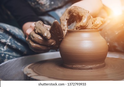 Women working on the potter's wheel. Hands sculpts a cup from clay pot. Workshop on modeling on the potter's wheel. - Powered by Shutterstock