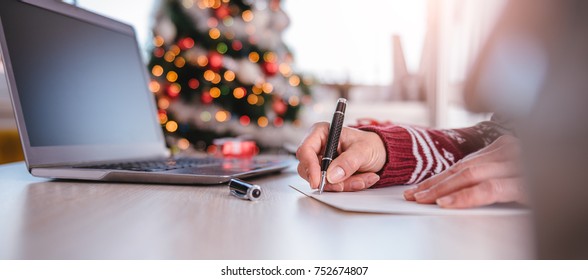 Women writing greeting cards at home office during christmas