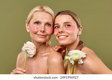 Women young and mature join together in a shared self-care routine, using under-eye patches to moisturize and white flowers to relax during their wellness routine. Cosmetology, skin care, spa. - Powered by Shutterstock