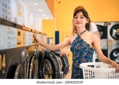 Womenl doing laundry in the laundromat looking at the camera with a smile