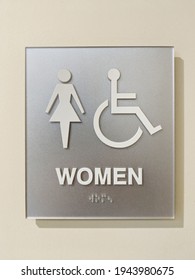 Womens ADA Accessible Bathroom Sign With Braille On Wall.
