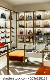 Women's bags, shoes and accessories on the shelves in the store. Vertical. Modern stylish fashion.