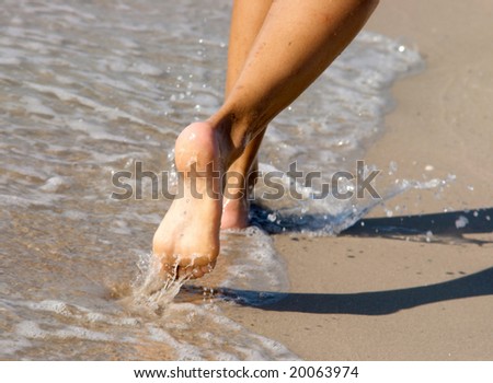 Women's barefoot legs on the beach