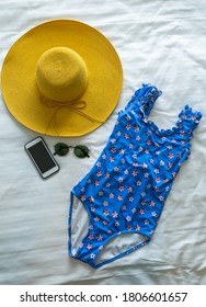 Women's beach accessories: swimsuit, sunglasses,phone,hat on bed