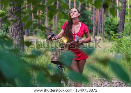 Women's bike. A woman is standing with a female bike in the forest.