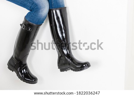 women's black rubber boots with blue jeans