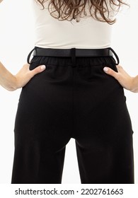 Women's Black Trousers. Woman In Pants And White Turtleneck. Clothes For Work, College Or School. Office Dress Code. Rear View. Comfortable Fit