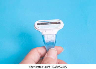 Womens Blue Razor In Hand On A Blue Background Close Up