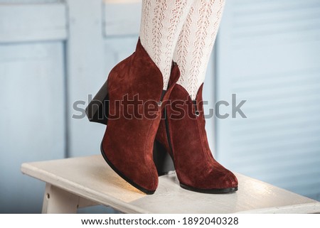 Womens brown suede fashion boots . slender female legs in white tights