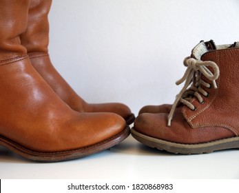 Women's And Children's Old Leather Boots Standing Face To Face    