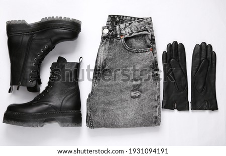 Women's clothing and accessories. Jeans and leather black boots, gloves on a white background. Top view