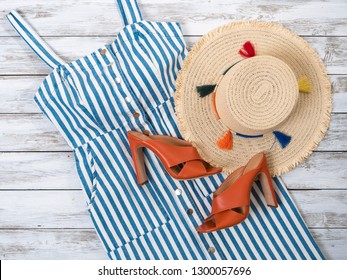 Womens clothing, accessories, shoes (white blue striped dress, straw hat, heels sandals). Fashion outfit, spring summer collection. Shopping concept. Flat lay, view from above