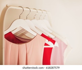Women's clothing in pink tones on a white hanger. Selective focus.