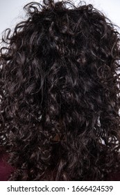 Women's Curly Brown Hair From Behind Over White Background. Detail Of Glossy Wavy Dark Hair. Hair Texture.