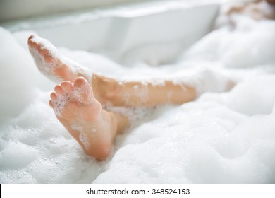 Women's feet she was bathing in a a bathtub with happiness