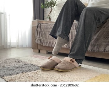 Women's feet in socks put on house slippers. Warm feet