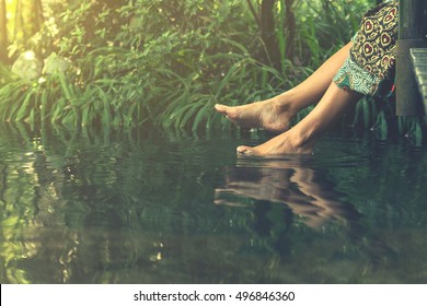 Women's feet in the water plunges feeling freshness