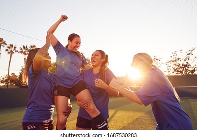 Womens Football Team Celebrating Winning Soccer Match Lifting Player Onto Shoulders