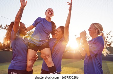 Womens Football Team Celebrating Winning Soccer Match Lifting Player Onto Shoulders