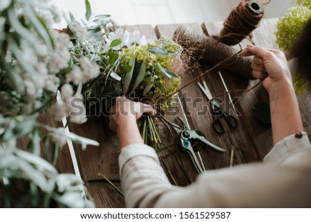 Similar – Woman making wild flowers at home in vase