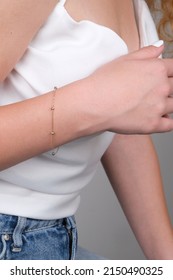 women's gold bracelet on the girl's hand, women's accessories, jewelry, gold bracelet with stones, women's jewelry, a girl with a bracelet on her arm, a bracelet with stones - Shutterstock ID 2150490325