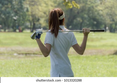 Women's golf Using golf clubs To help twist To warm up body before the play game with blurred soft nature background.  - Powered by Shutterstock